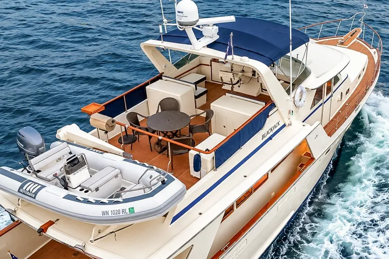 Slide: The Image of 1991 Tollycraft 61 Pilothouse Motor Yacht cruising on open water, featuring a spacious deck. - 9