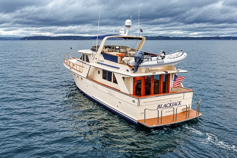 Slide: The Image of 1991 Tollycraft 61 Pilothouse Motor Yacht cruising on open water under cloudy skies. - 4