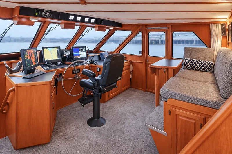 Slide: The Image of 1991 Tollycraft 61 Pilothouse Motor Yacht interior with helm, navigation equipment, and seating area. - 22