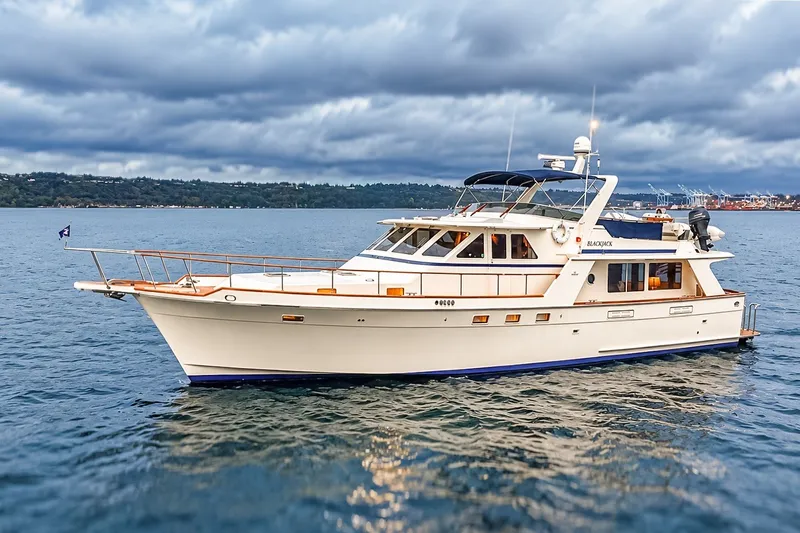 Slide: The Image of 1991 Tollycraft 61 Pilothouse Motor Yacht on calm waters under cloudy sky. - 1