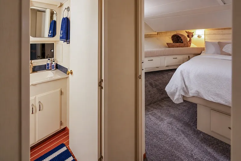 Slide: The Image of Interior of 1991 Tollycraft 61 Pilothouse Motor Yacht, featuring cozy bedroom and bathroom. - 39