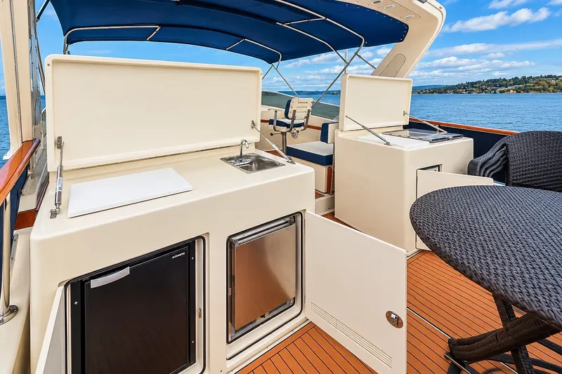 Slide: The Image of 1991 Tollycraft 61 Pilothouse Motor Yacht deck with outdoor kitchen and seating area. - 54
