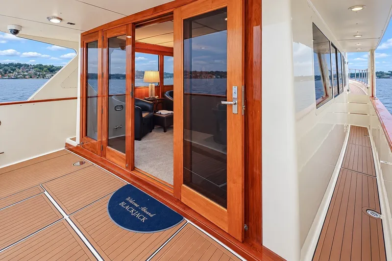 Slide: The Image of 1991 Tollycraft 61 Pilothouse Motor Yacht with elegant wooden doors and scenic water view. - 10