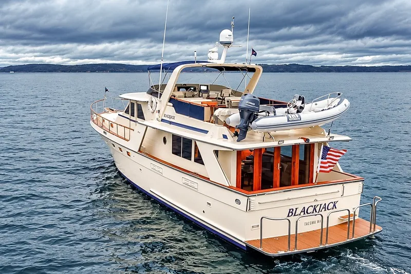 Slide: The Image of 1991 Tollycraft 61 Pilothouse Motor Yacht on open water, rear view with American flag. - 6
