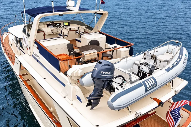 Slide: The Image of 1991 Tollycraft 61 Pilothouse Motor Yacht with Novurania tender on deck, cruising on open water. - 8