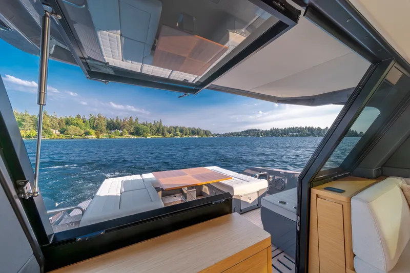 Slide: The Image of 2023 Pardo Yachts GT52 interior with open deck, overlooking serene lake and forest. - 20