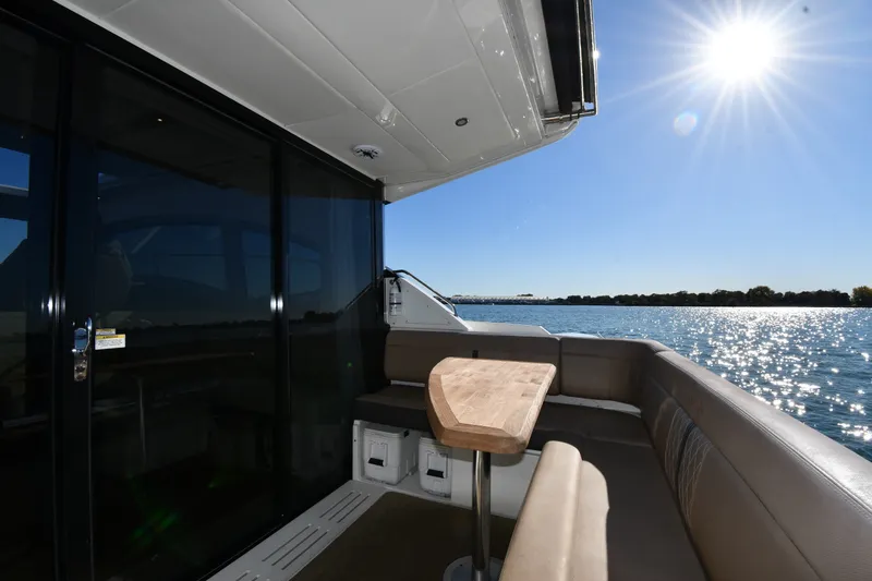 Slide: The Image of 2017 Sea Ray Sundancer 400 yacht deck with seating, table, and sunny waterfront view. - 8