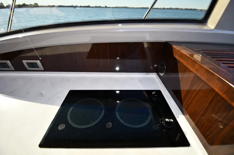 Slide: The Image of Modern kitchen area on 2017 Sea Ray Sundancer 400 yacht with sleek cooktop. - 44