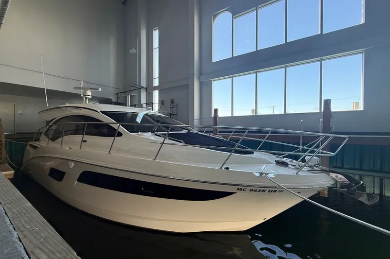 Slide: The Image of 2017 Sea Ray Sundancer 400 yacht docked indoors with large windows. - 57