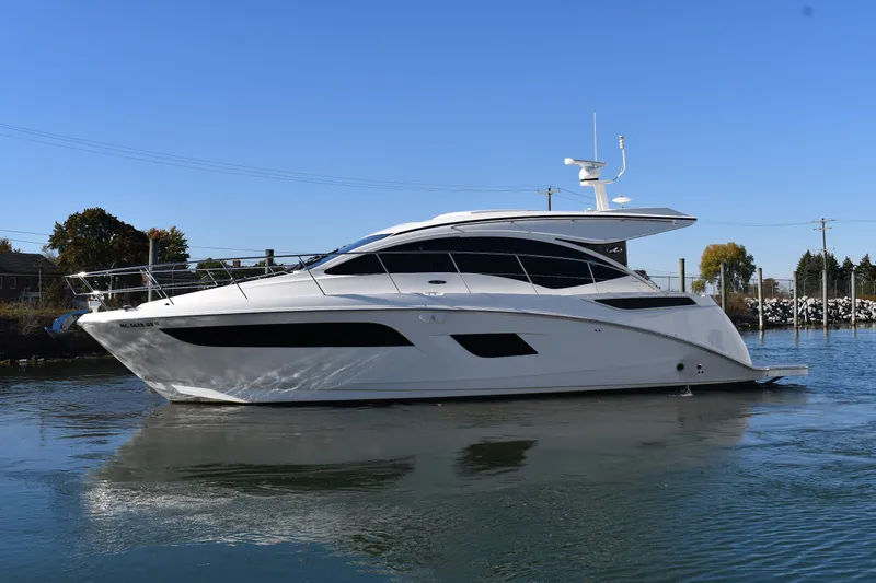 Slide: The Image of 2017 Sea Ray Sundancer 400 yacht cruising on calm water under clear blue sky. - 2