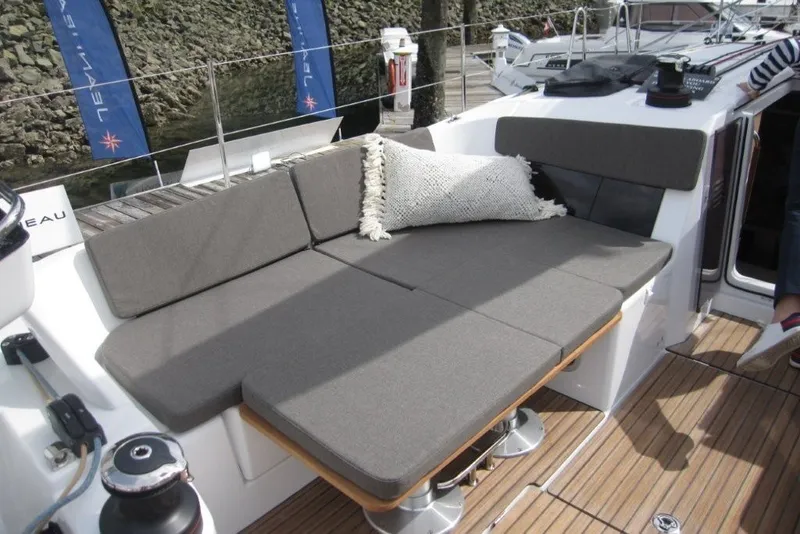 Slide: The Image of 2027 Jeanneau Sun Odyssey 455 yacht with cushioned seating and wooden deck. - 34