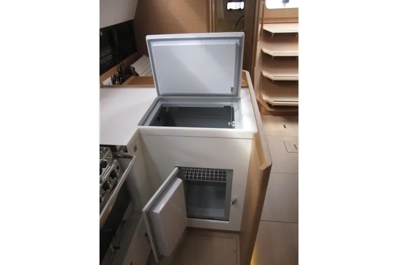 Slide: The Image of 2027 Jeanneau Sun Odyssey 455 yacht interior with open fridge and freezer in galley. - 8