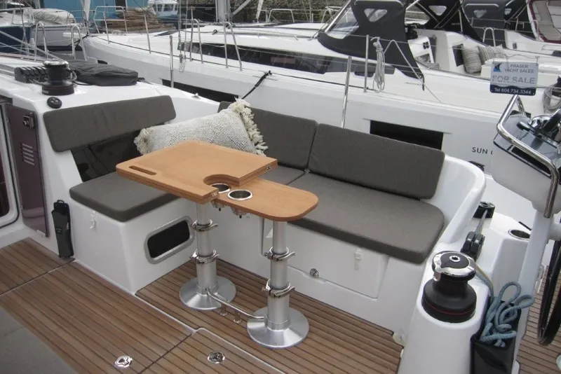 Slide: The Image of 2027 Jeanneau Sun Odyssey 455 yacht cockpit with cushioned seating and wooden table. - 32