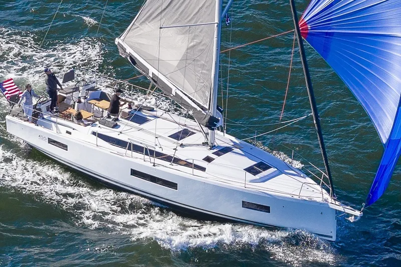The Image of 2027 Jeanneau Sun Odyssey 455 sailing on open water with vibrant blue spinnaker. - 0