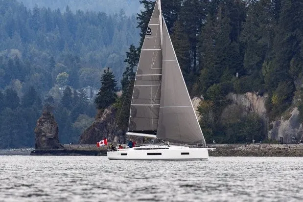 Slide: The Image of 2027 Jeanneau Sun Odyssey 455 sailing near forested coastline with Canadian flag. - 52