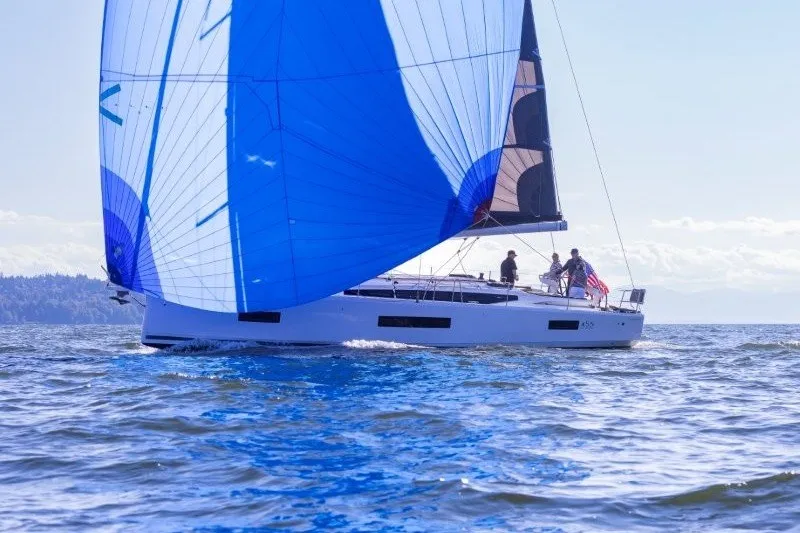 Slide: The Image of 2027 Jeanneau Sun Odyssey 455 sailing with a vibrant blue spinnaker on open water. - 47