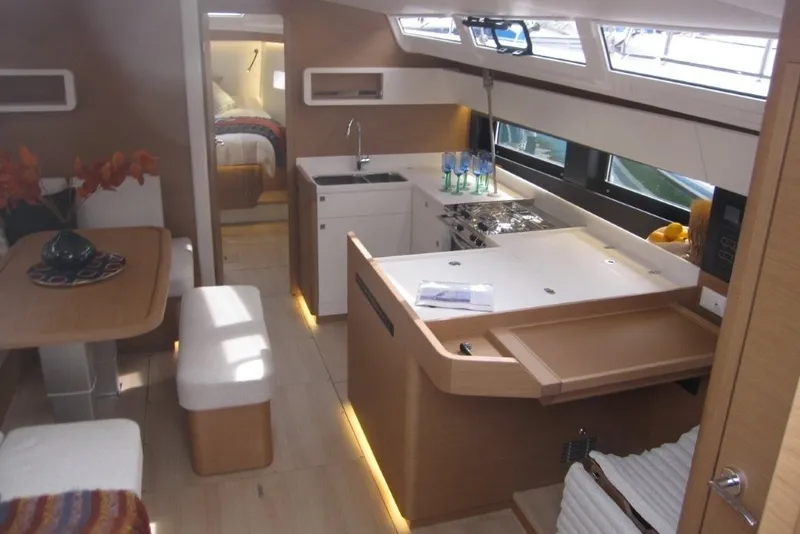 Slide: The Image of Interior of 2027 Jeanneau Sun Odyssey 455 yacht, featuring modern kitchen and dining area. - 3