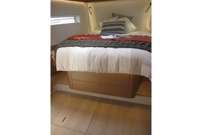 Slide: The Image of Interior cabin of 2027 Jeanneau Sun Odyssey 455 yacht, featuring a cozy bed and wooden flooring. - 14