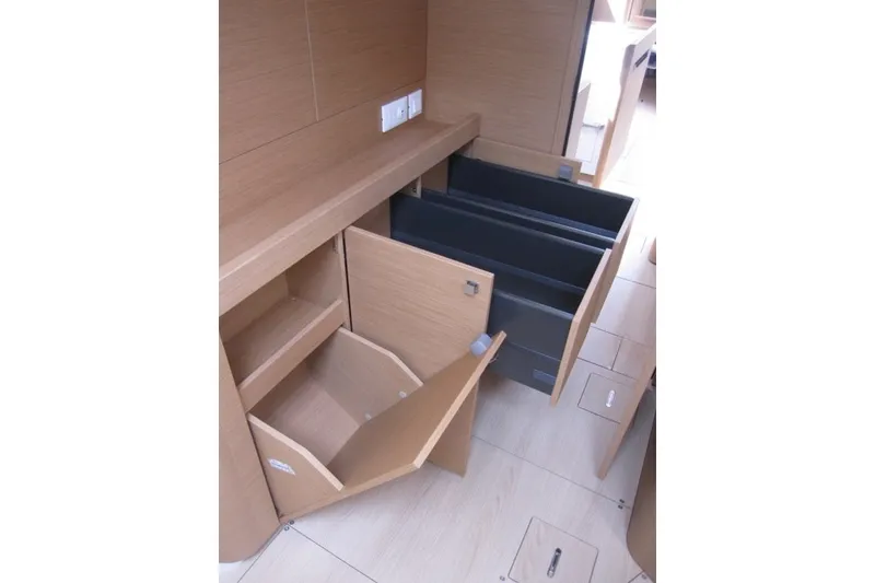 Slide: The Image of Interior storage compartments of 2027 Jeanneau Sun Odyssey 455 yacht, featuring open wooden cabinets. - 19
