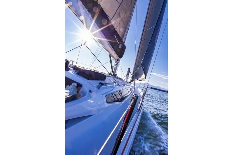Slide: The Image of 2027 Jeanneau Sun Odyssey 455 sailing on open water under bright sun. - 49