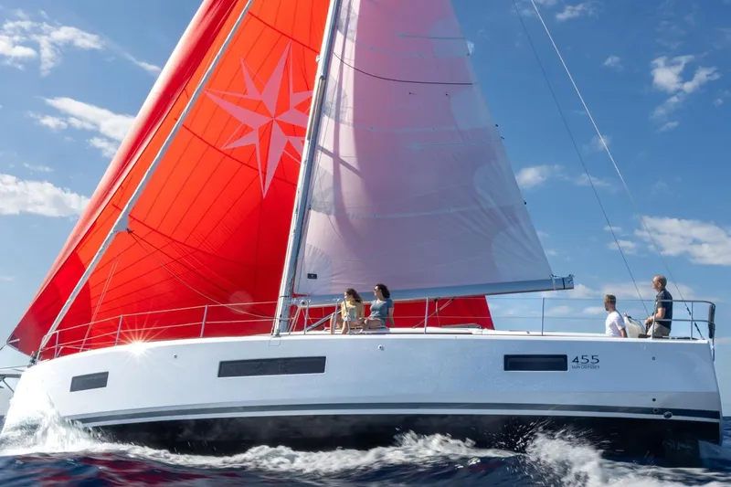 Slide: The Image of Manufacturer Provided Image: 2026 Jeanneau Sun Odyssey 455 sailing with vibrant red sails on open water. - 43