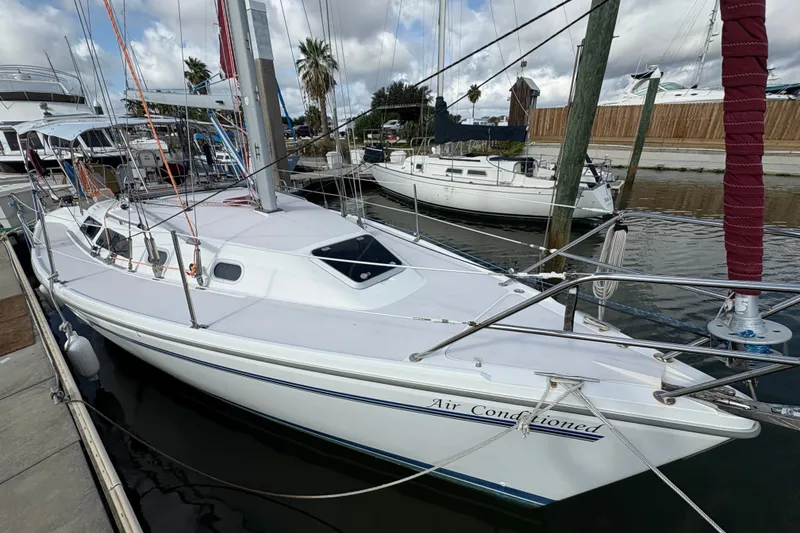 Slide: The Image of 2004 Catalina 310 sailboat docked at marina, featuring sleek design and spacious deck. - 7