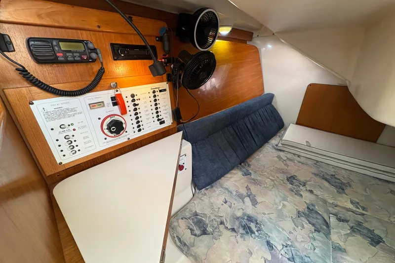 Slide: The Image of Interior of a 2004 Catalina 310 sailboat with control panel and cozy sleeping area. - 17