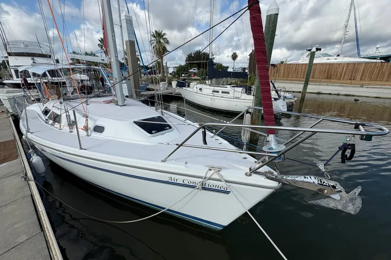 Slide: The Image of 2004 Catalina 310 sailboat docked at a marina under cloudy skies. - 6