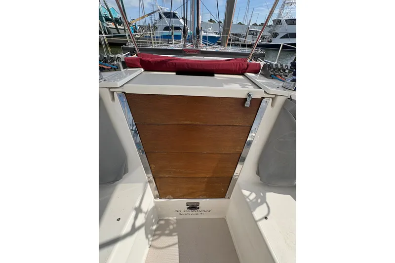 Slide: The Image of Cockpit view of a 2004 Catalina 310 sailboat with wooden hatch and marina background. - 15