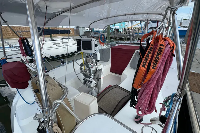 Slide: The Image of 2004 Catalina 310 sailboat cockpit with steering wheel, ropes, and navigation equipment. - 5