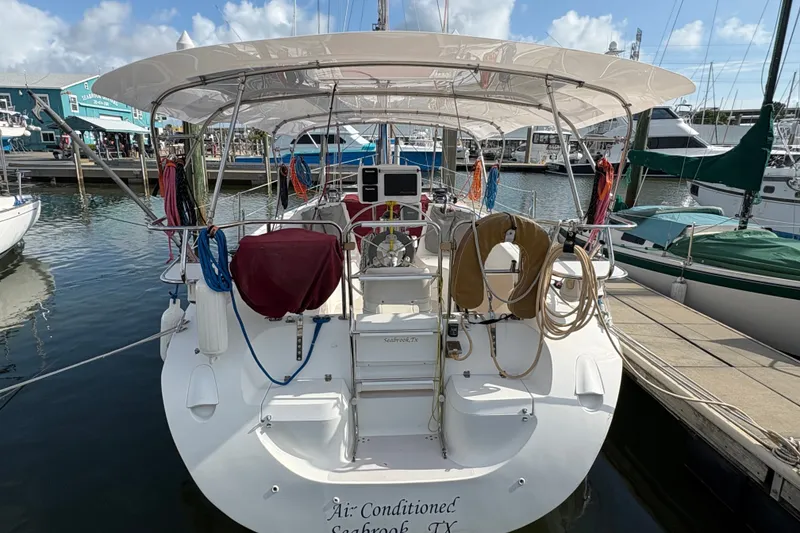 Slide: The Image of Catalina 310 sailboat, 2004 model, docked at marina with covered cockpit and nautical equipment. - 3