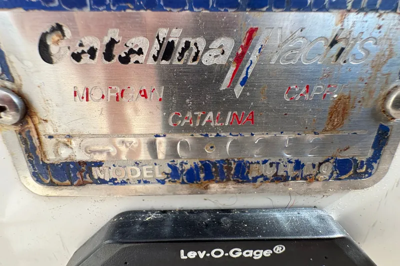 Slide: The Image of 2004 Catalina 310 yacht nameplate with visible wear and rust. - 16