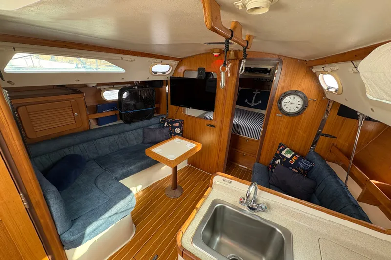 Slide: The Image of Interior of 2004 Catalina 310 sailboat with cozy seating, wood finish, and nautical decor. - 20