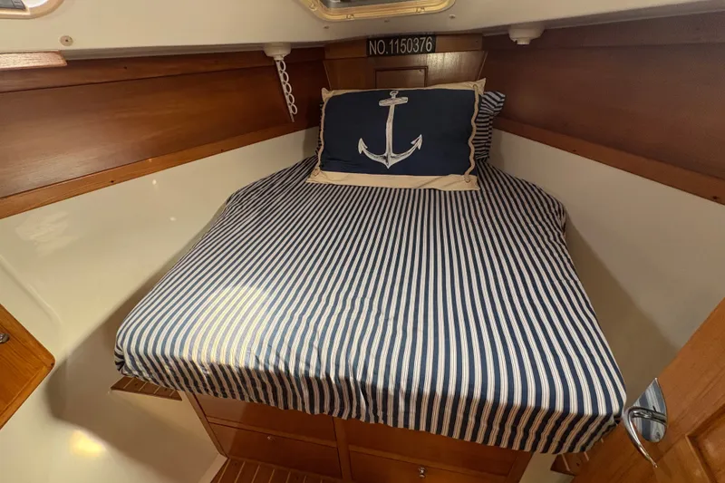 Slide: The Image of Cozy cabin bed in 2004 Catalina 310 sailboat with nautical-themed decor. - 26