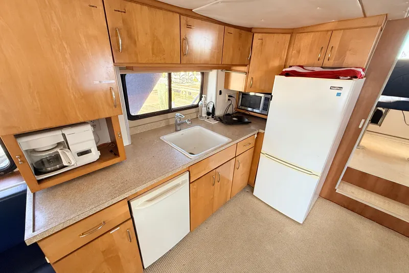 Slide: The Image of Kitchen area of 2013 Silver Ships Inc Barrows 60 with wooden cabinets and appliances. - 13