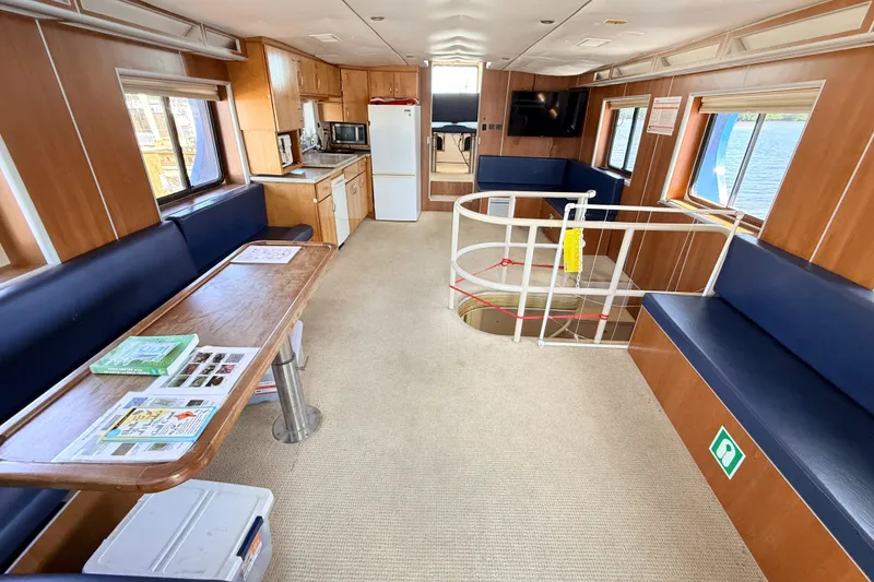 Slide: The Image of Interior of 2013 Silver Ships Inc Barrows 60, featuring seating, table, and kitchenette. - 16