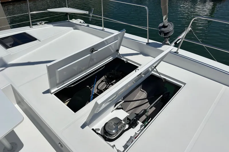 Slide: The Image of Open storage compartments on a 2023 Bali 4.4 boat deck, docked by the water. - 25