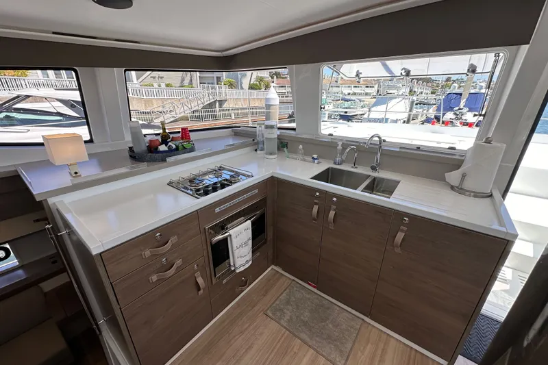 Slide: The Image of Modern yacht kitchen interior with dual sinks, stove, and ample storage on a 2023 Bali 4.4 model. - 59