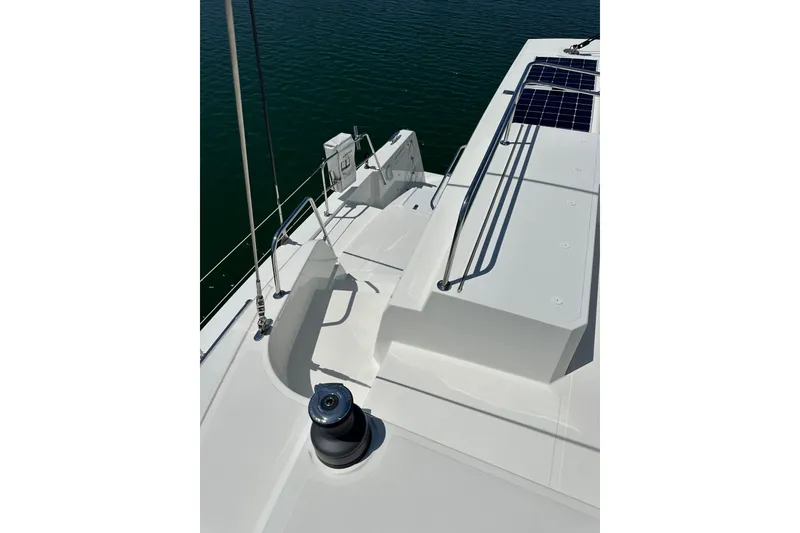 Slide: The Image of 2023 Bali 4.4 yacht deck with solar panels and winch, overlooking calm water. - 48