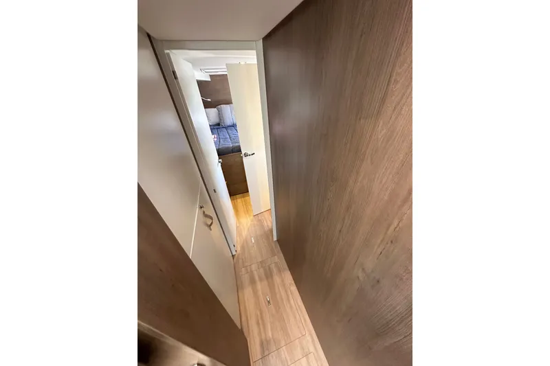 Slide: The Image of Narrow hallway in 2023 Bali 4.4 yacht, leading to a cozy bedroom with wooden interior. - 89
