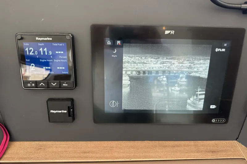 Slide: The Image of Boat control panel with Raymarine displays showing voltage, depth, and thermal imaging. Bali 4.4, 2023 model. - 64