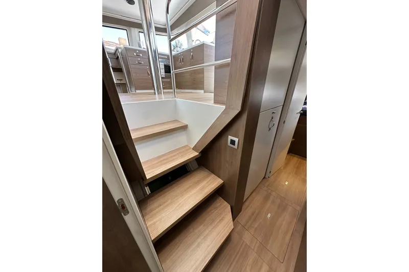 Slide: The Image of Wooden staircase inside 2023 Bali 4.4 yacht, leading to upper deck with modern interior design. - 100