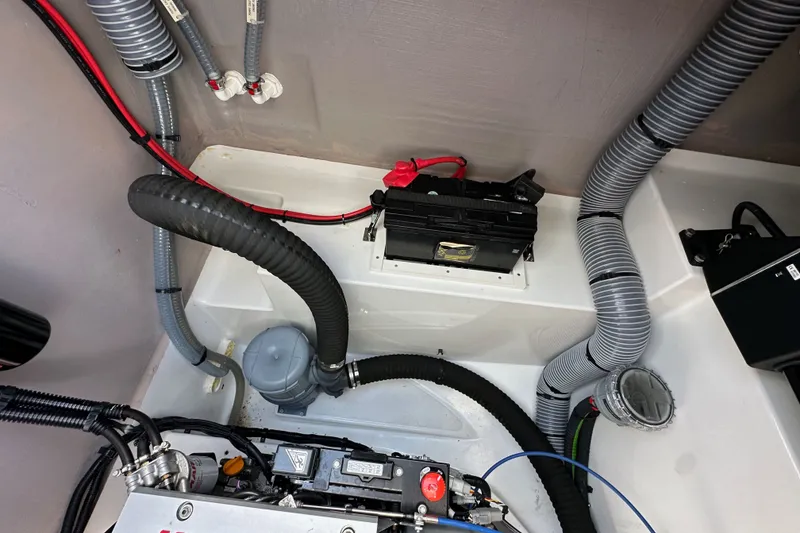 Slide: The Image of Engine compartment of a 2023 Bali 4.4, featuring battery and wiring components. - 105