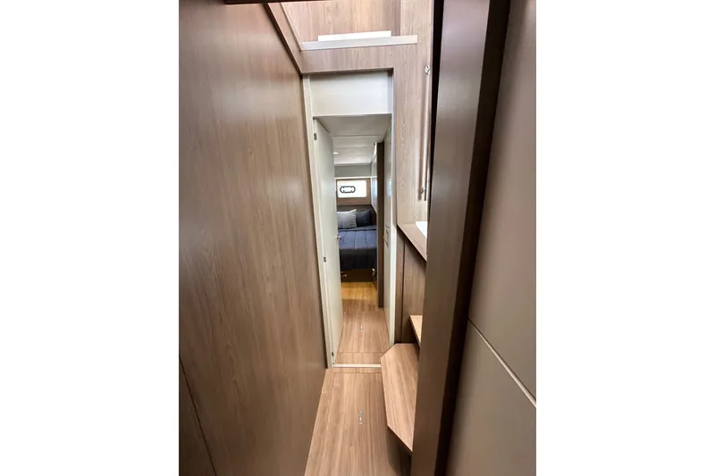 Slide: The Image of Narrow hallway inside 2023 Bali 4.4 yacht, leading to a cozy bedroom. - 95