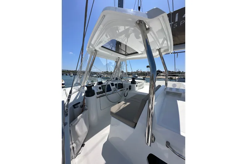 Slide: The Image of 2023 Bali 4.4 yacht cockpit with steering wheel, sleek design, and marina view. - 32
