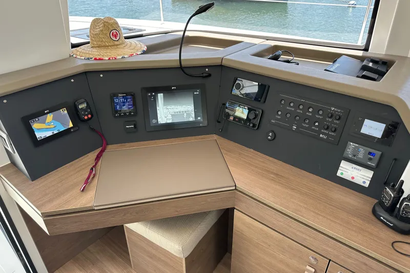 Slide: The Image of Control panel of a 2023 Bali 4.4 yacht with navigation equipment and a straw hat. - 62