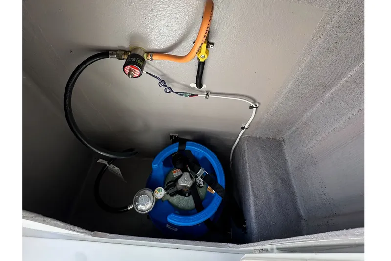 Slide: The Image of Propane tank setup in a Bali 4.4 model, 2023, with connected hoses and regulator. - 116
