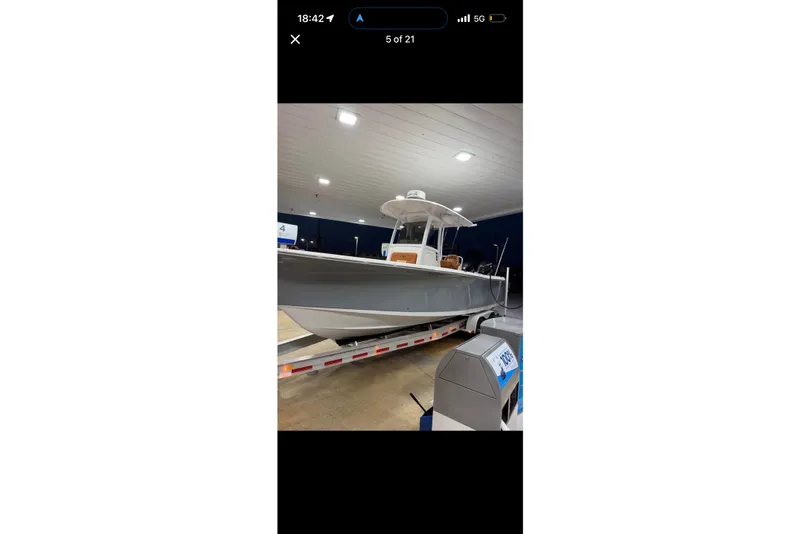 The Image of 2014 Sea Hunt Gamefish 27 boat on trailer in indoor setting. - 0