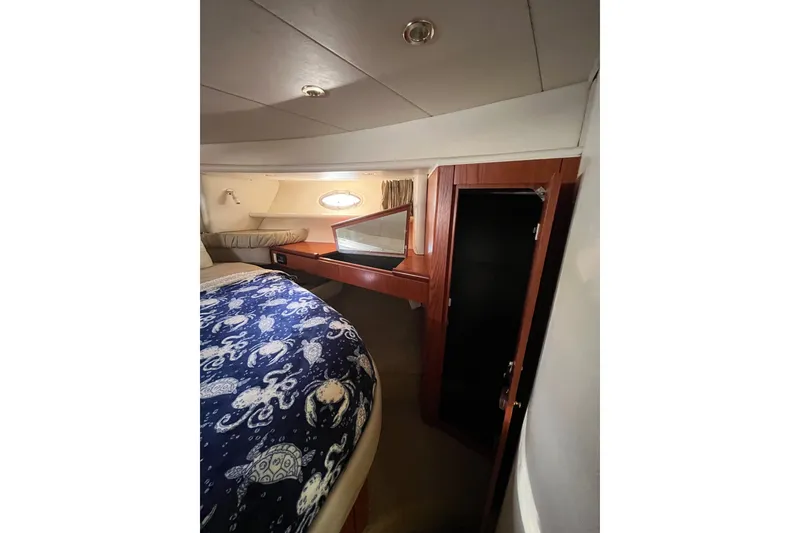 Slide: The Image of Cozy cabin interior of 1999 Maxum 4600 SCB yacht with nautical-themed bedding. - 20