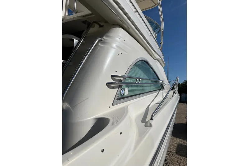 Slide: The Image of Side view of a 1999 Maxum 4600 SCB yacht with sleek design and chrome railings. - 32